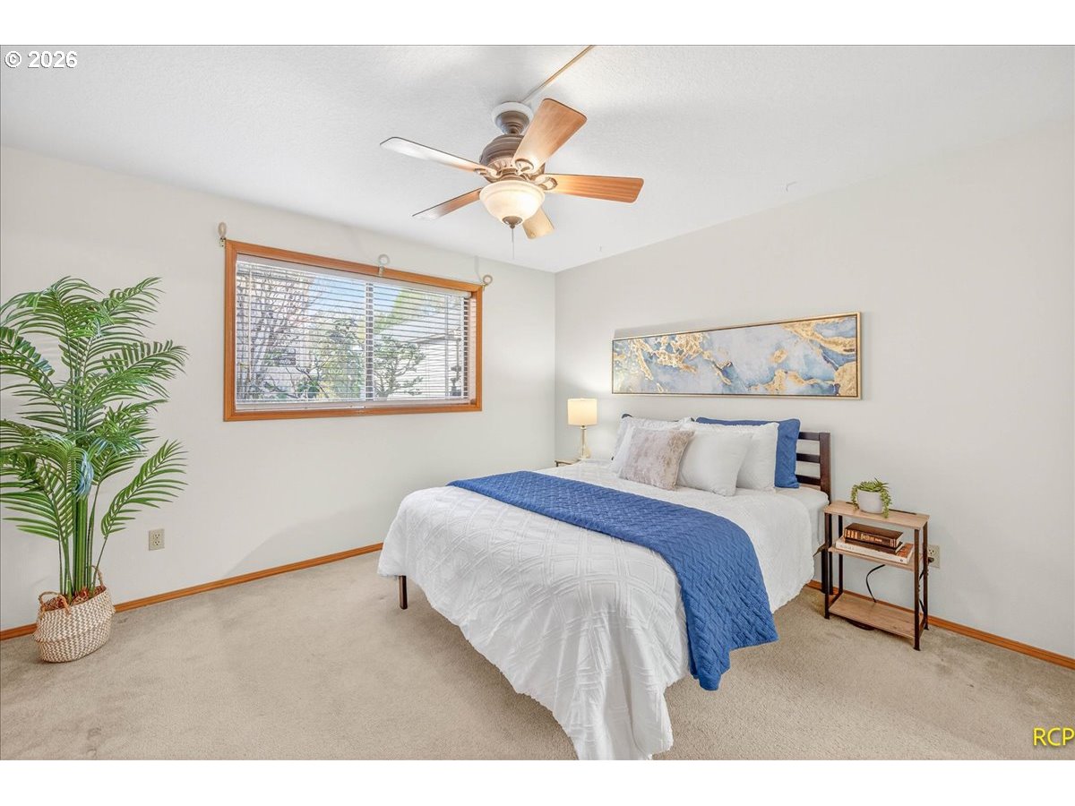 16444 Southwest 130th Terrace, Unit 121 Portland, OR 97224 - Photo 26 of 40 a bedroom with a large bed and a chandelier