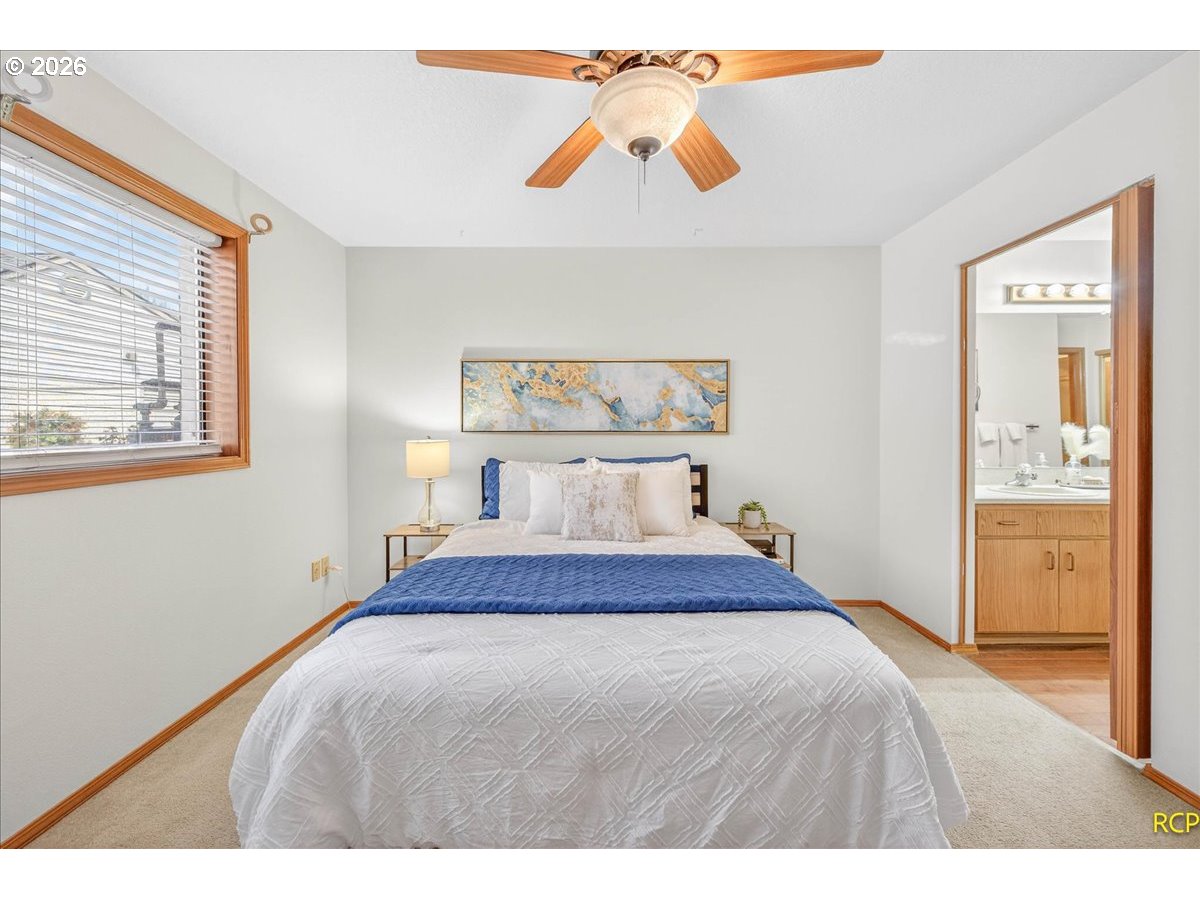 16444 Southwest 130th Terrace, Unit 121 Portland, OR 97224 - Photo 27 of 40 a bedroom with a bed and a painting on the wall