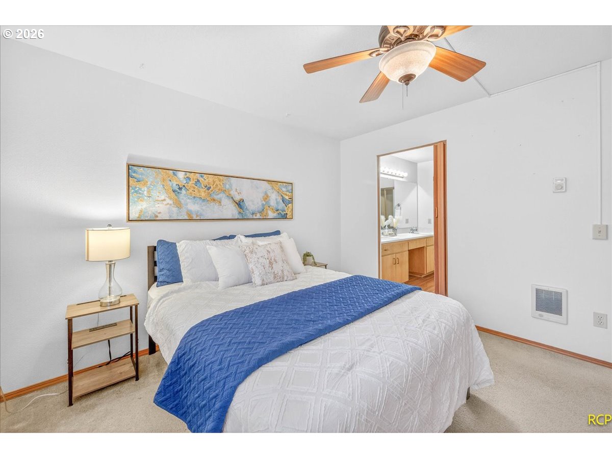 16444 Southwest 130th Terrace, Unit 121 Portland, OR 97224 - Photo 28 of 40 a bedroom with a bed and a chandelier