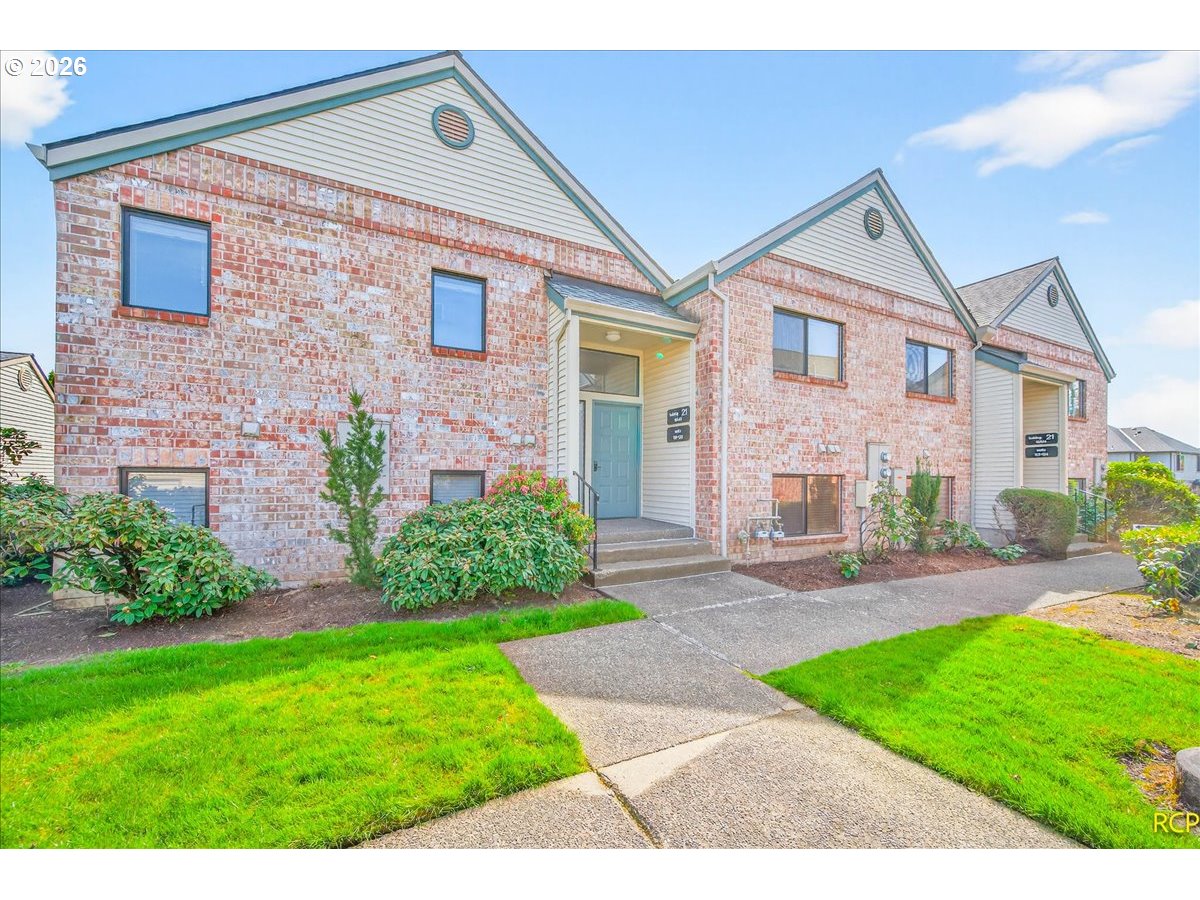 16444 Southwest 130th Terrace, Unit 121 Portland, OR 97224 - Photo 3 of 40 a front view of a house with a yard and plants