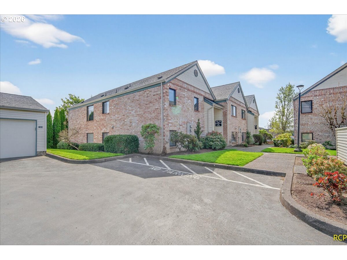 16444 Southwest 130th Terrace, Unit 121 Portland, OR 97224 - Photo 33 of 40 a view of a house with a big yard and large trees