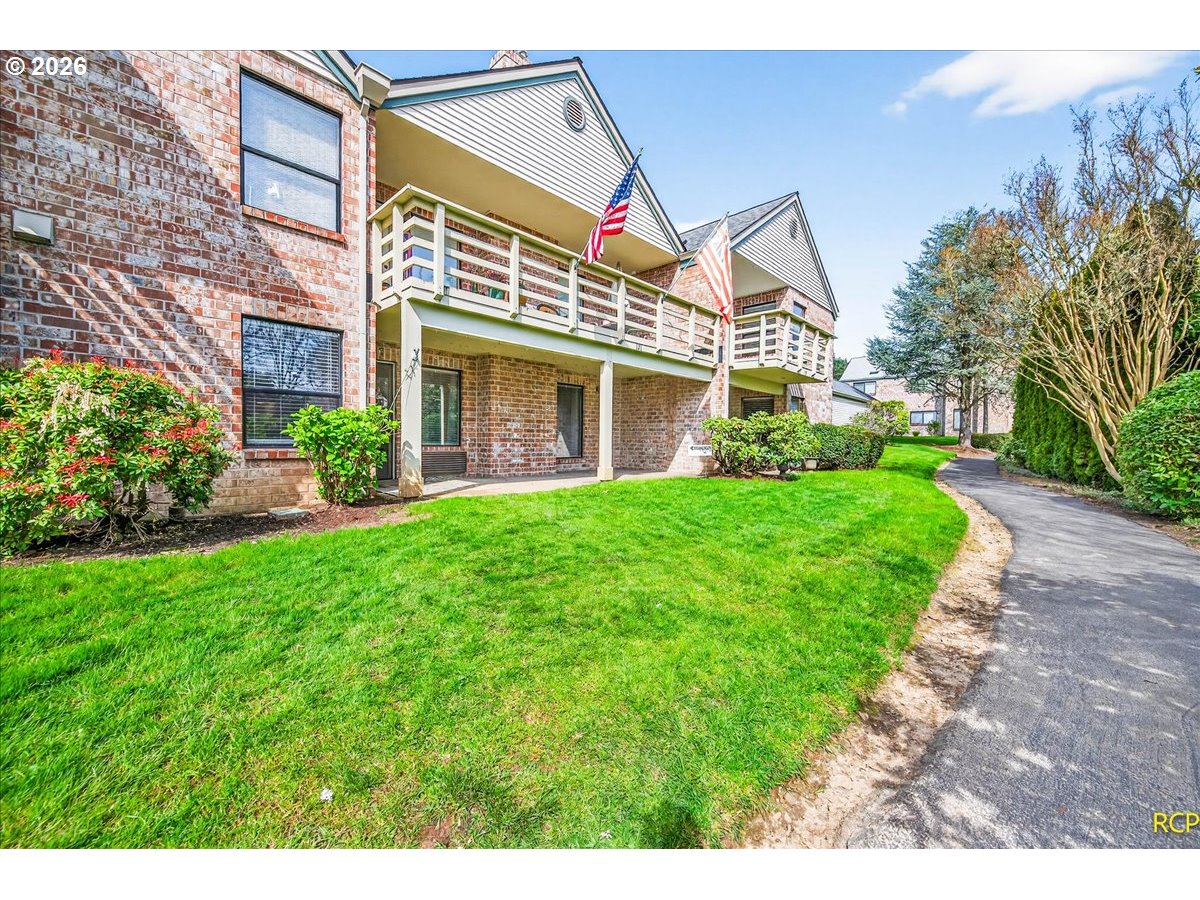 16444 Southwest 130th Terrace, Unit 121 Portland, OR 97224 - Photo 4 of 40 a view of a brick house with a yard and plants