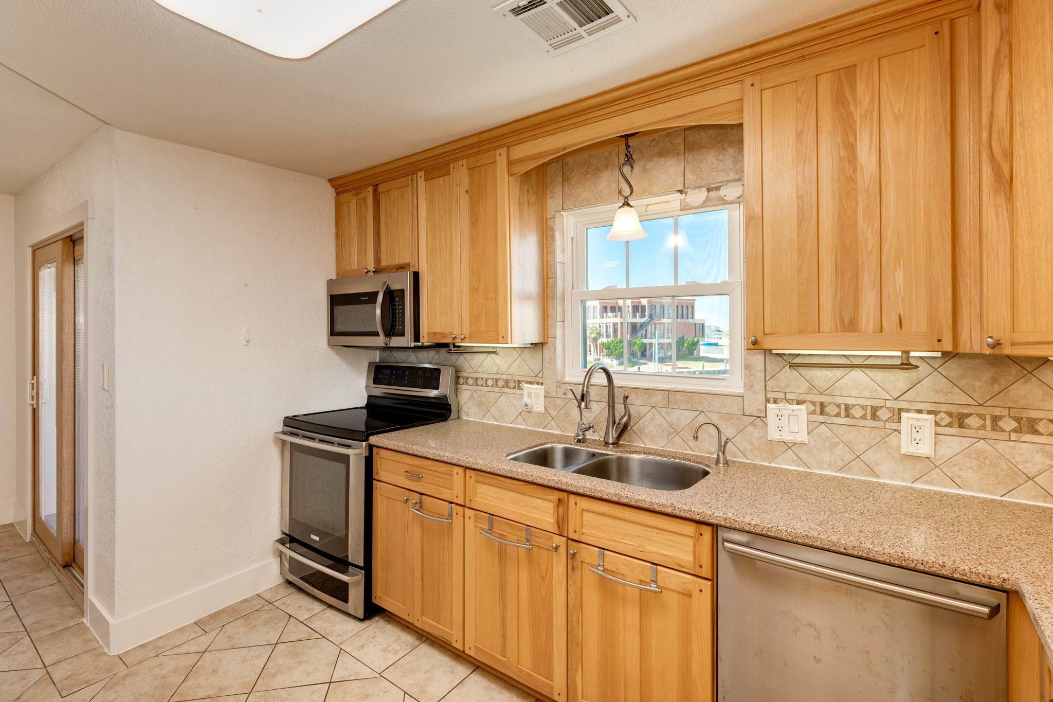 411 Sailfish Lane, Unit 101 Freeport, TX 77541 - Photo 25 of 46 a kitchen with stainless steel appliances a sink stove and cabinets