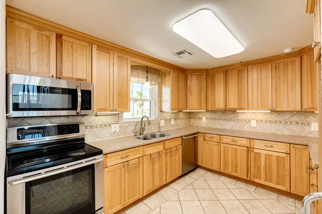 a kitchen with stainless steel appliances granite countertop a stove sink and microwave