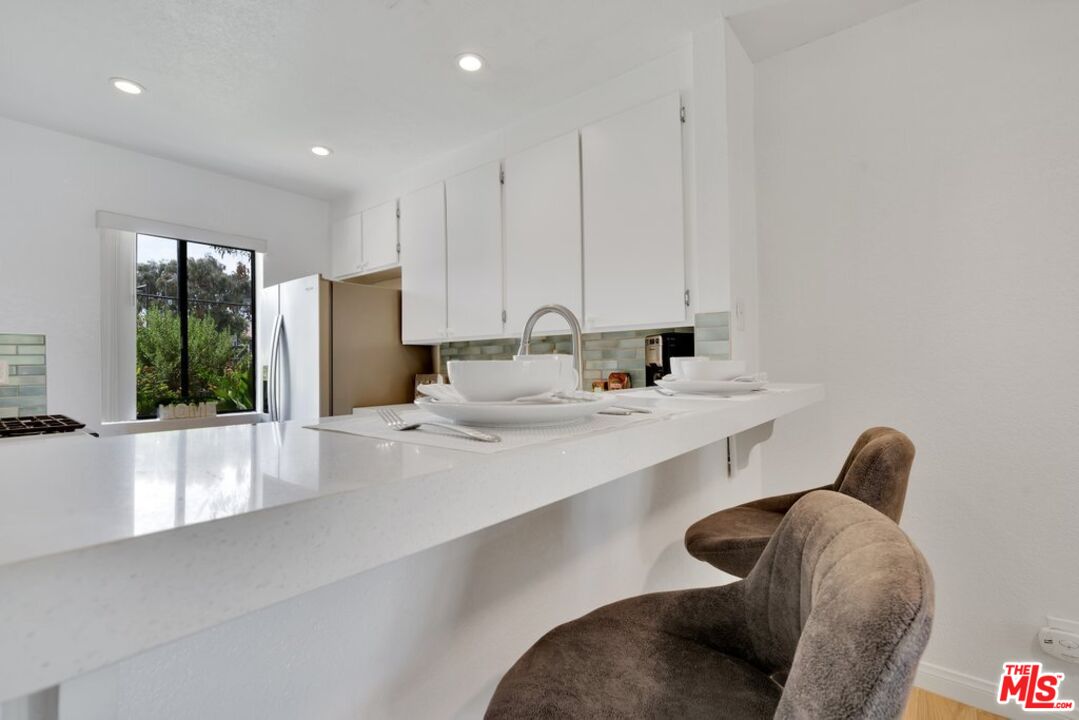 48255 Monroe Street, Unit 56 Indio, CA 92201 - Photo 4 of 30 a large white kitchen with a refrigerator a sink and a large window