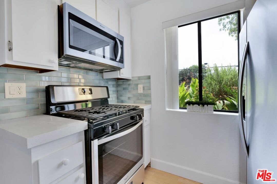 48255 Monroe Street, Unit 56 Indio, CA 92201 - Photo 5 of 30 a kitchen with stainless steel appliances a stove a microwave and a window