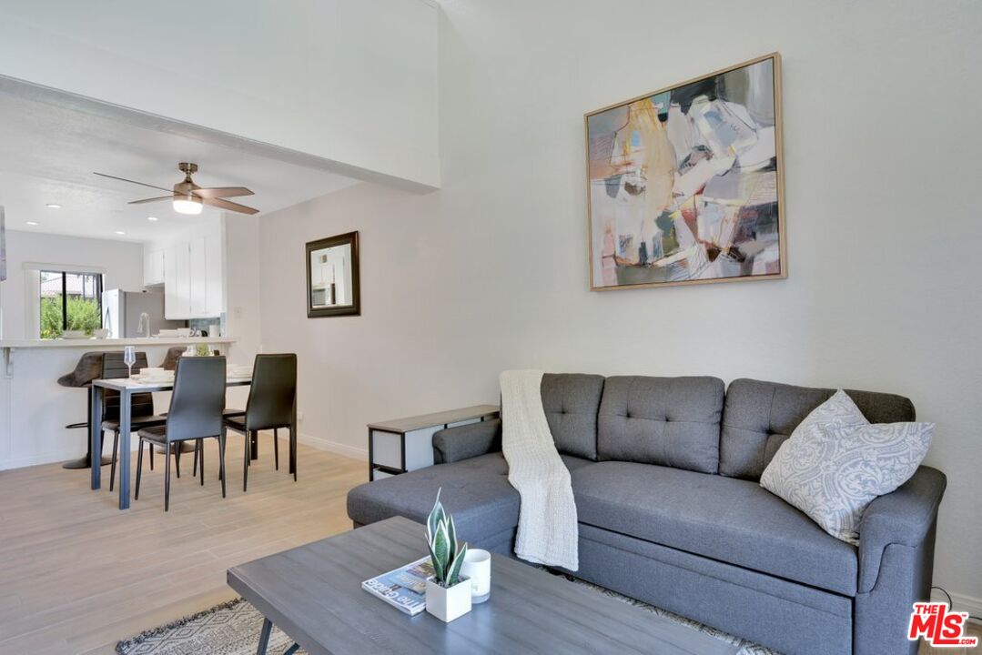 48255 Monroe Street, Unit 56 Indio, CA 92201 - Photo 10 of 30 a living room with furniture a dining table and wooden floor