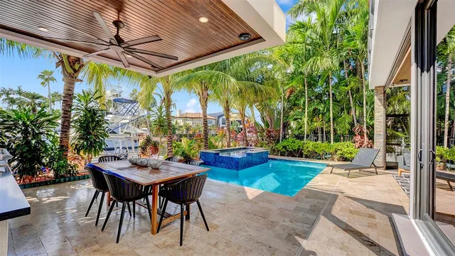 a kitchen with stainless steel appliances kitchen island granite countertop a table chairs and a refrigerator