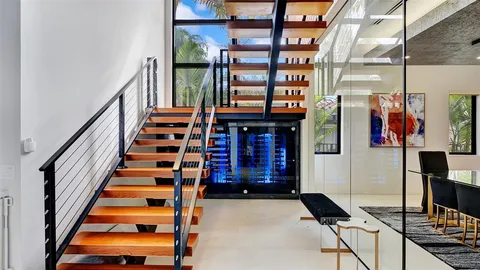 a bedroom with a bed and a large mirror with wooden floor
