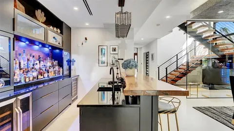 a bedroom with a bed a couch and a large window with wooden floor