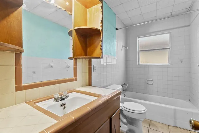 a bathroom with a sink and mirror with toilet
