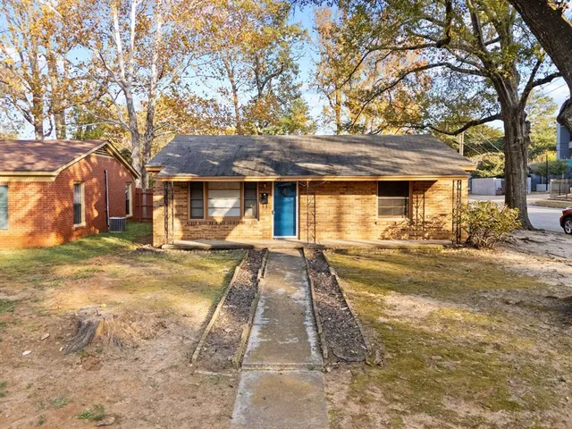 a view of a white house with a large tree