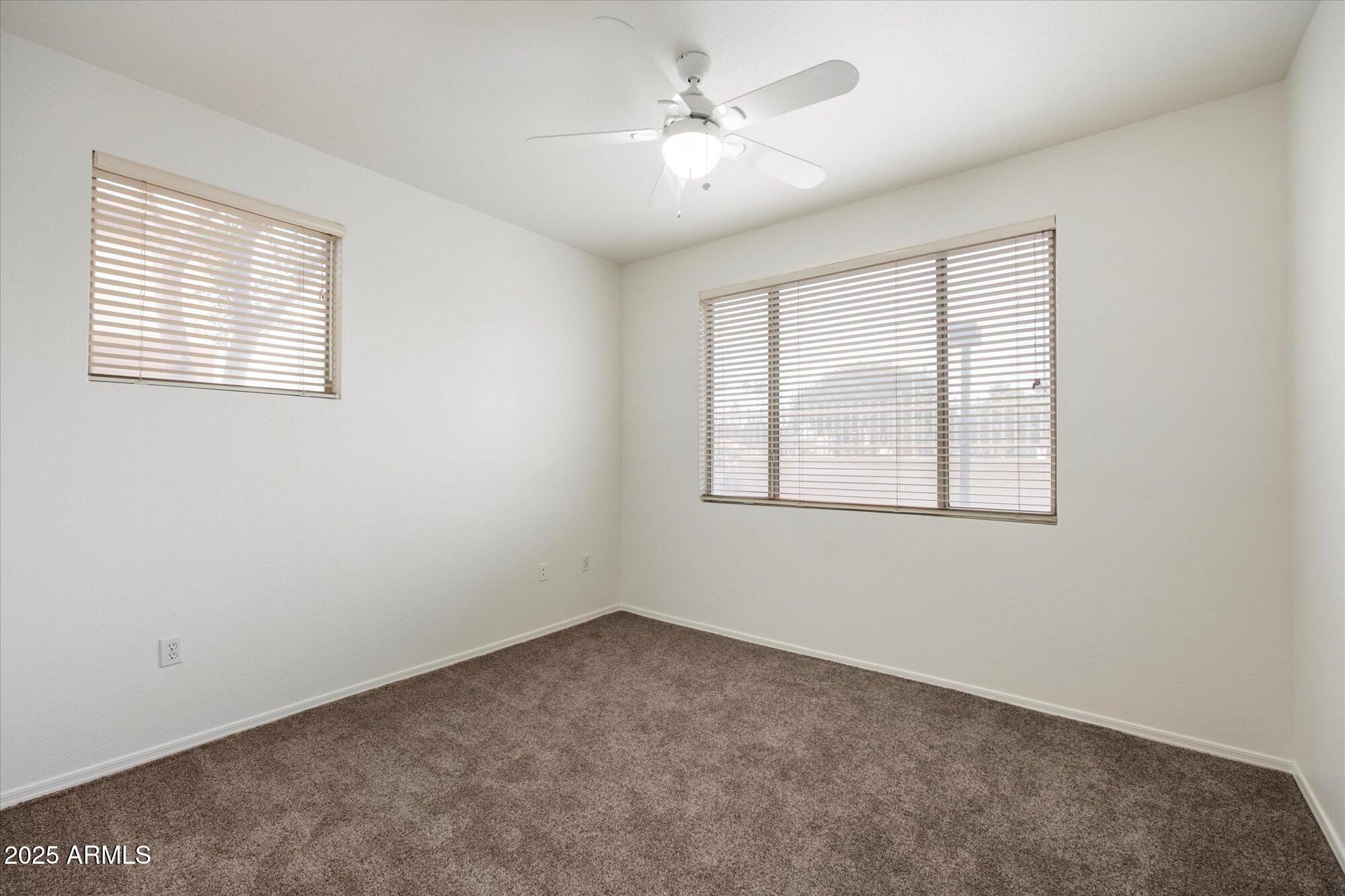 1445 East Broadway Road, Unit 120 Tempe, AZ 85282 - Photo 20 of 39 an empty room with windows and ceiling fan
