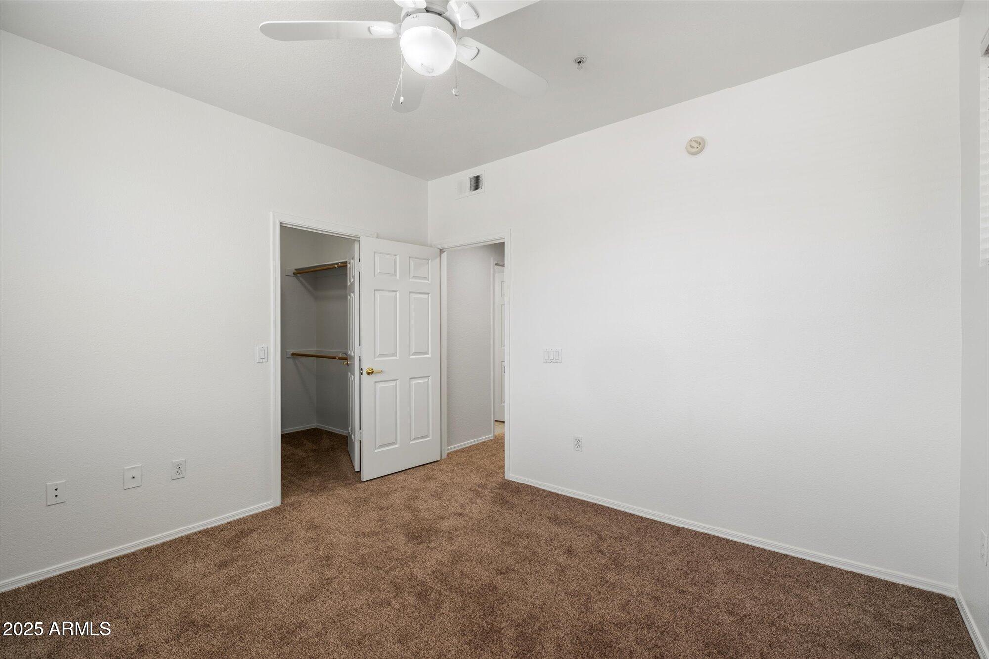 1445 East Broadway Road, Unit 120 Tempe, AZ 85282 - Photo 21 of 39 an empty room with a ceiling fan and carpet