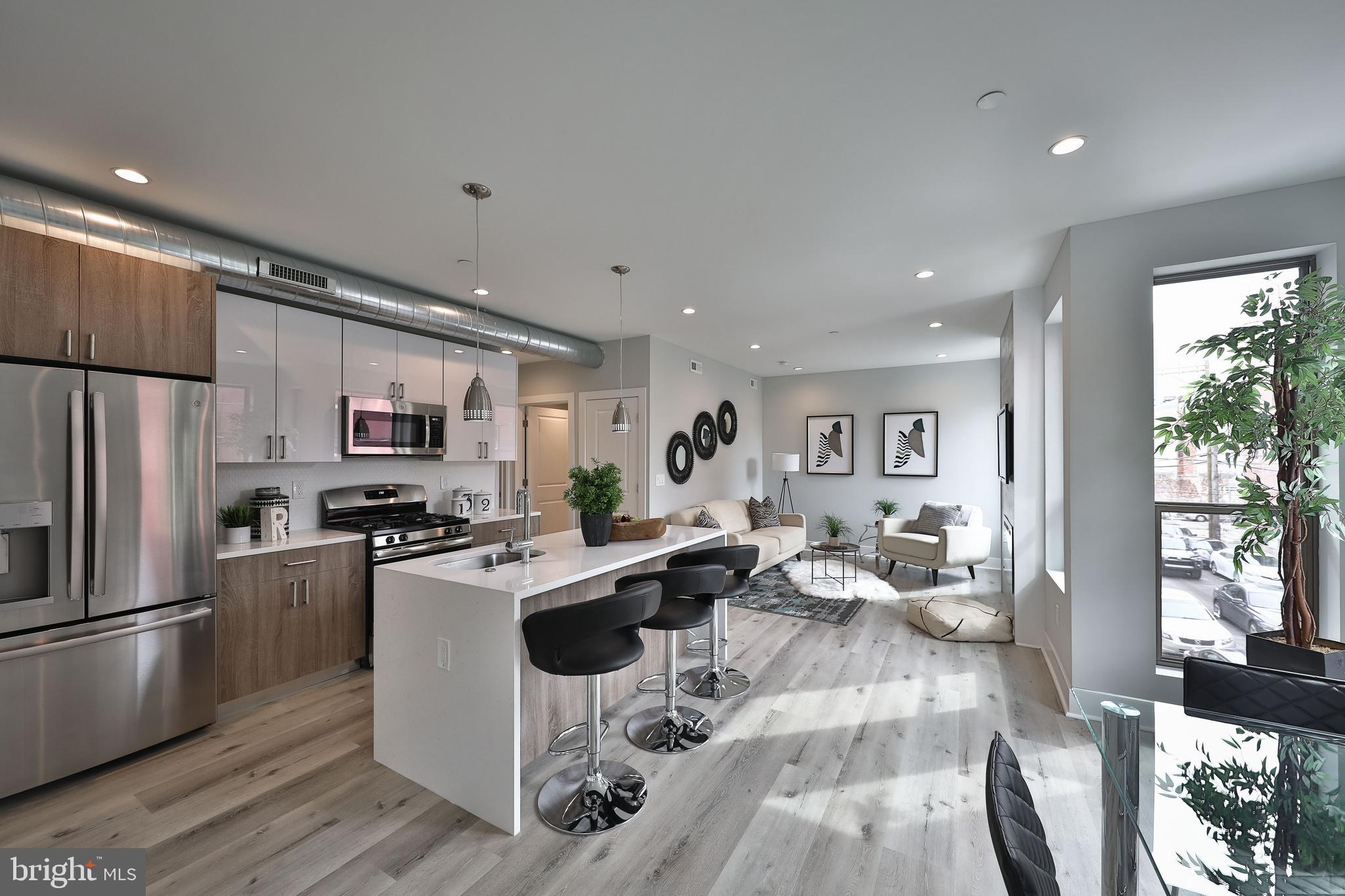 1540-42 Ridge Avenue, Unit 2S Philadelphia, PA 19130 - Photo 12 of 20 a living room with stainless steel appliances furniture a flat screen tv and a kitchen view