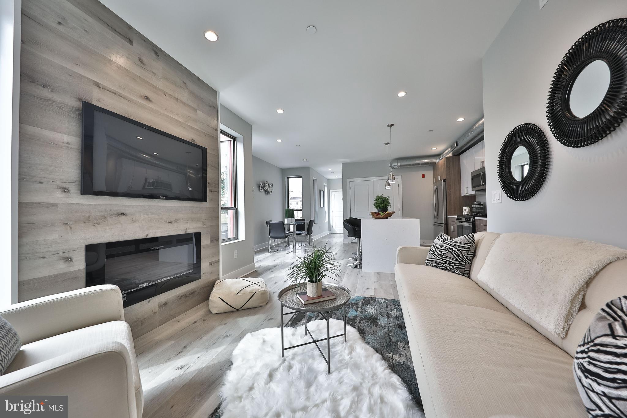 1540-42 Ridge Avenue, Unit 2S Philadelphia, PA 19130 - Photo 15 of 20 a living room with furniture a fireplace and a flat screen tv