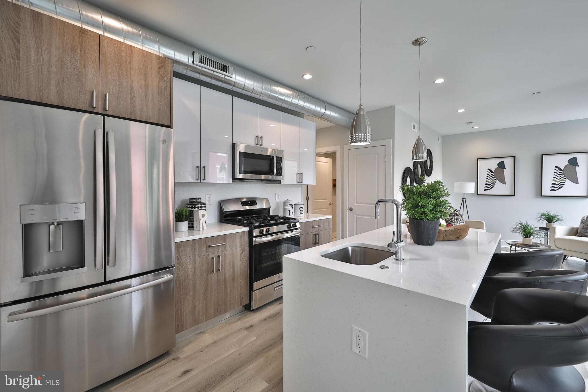 1540-42 Ridge Avenue, Unit 2S Philadelphia, PA 19130 - Photo 3 of 20 a kitchen with kitchen island a counter appliances a sink and cabinets