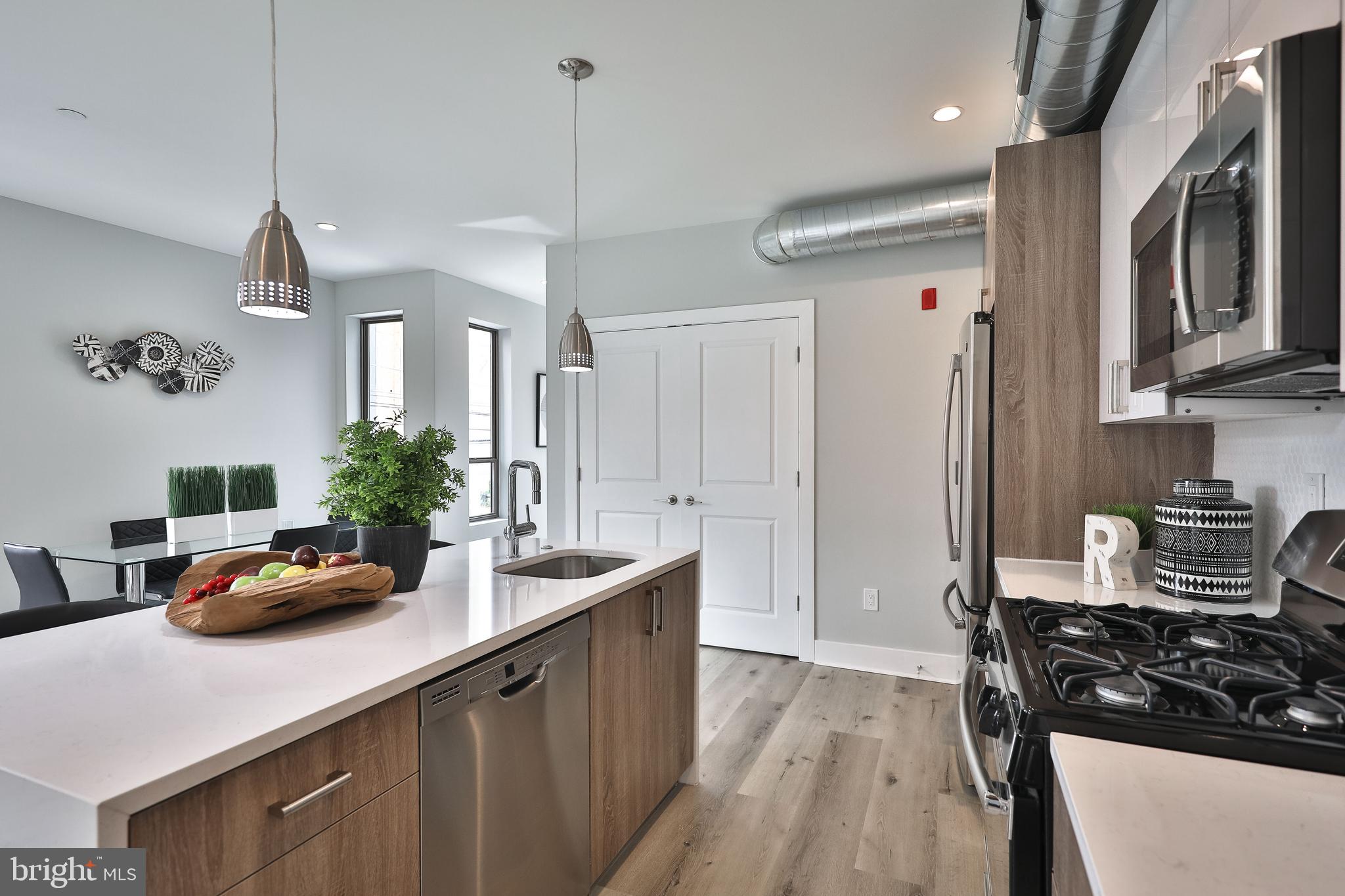 1540-42 Ridge Avenue, Unit 2S Philadelphia, PA 19130 - Photo 8 of 20 a kitchen with stainless steel appliances a sink a stove a refrigerator and cabinets