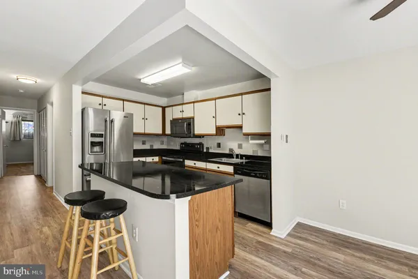 a kitchen with stainless steel appliances granite countertop a refrigerator and a stove top oven