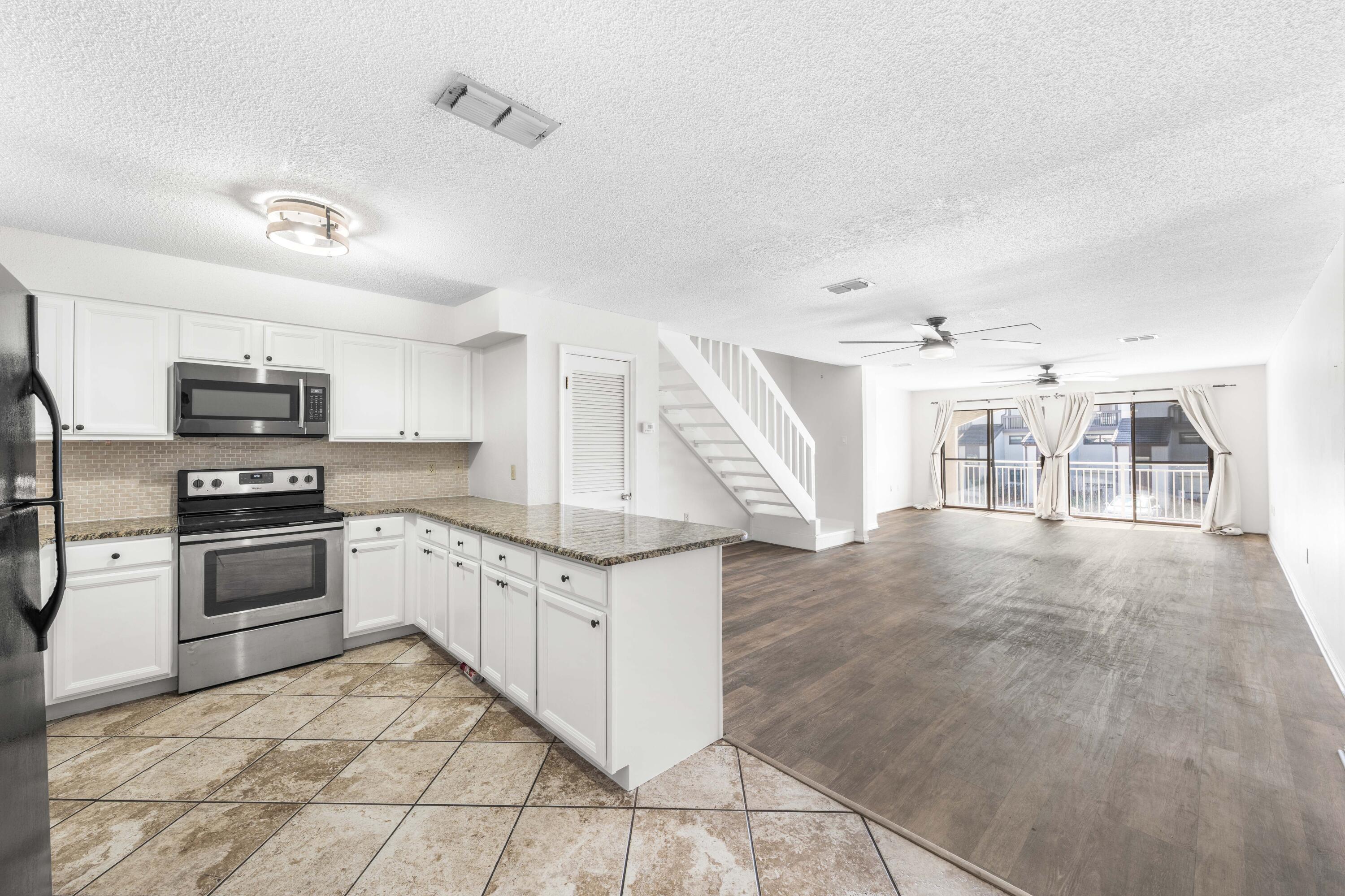 3654 East County Highway 30A, Unit 8B Santa Rosa Beach, FL 32459 - Photo 6 of 42 a kitchen with granite countertop a stove top oven and cabinets