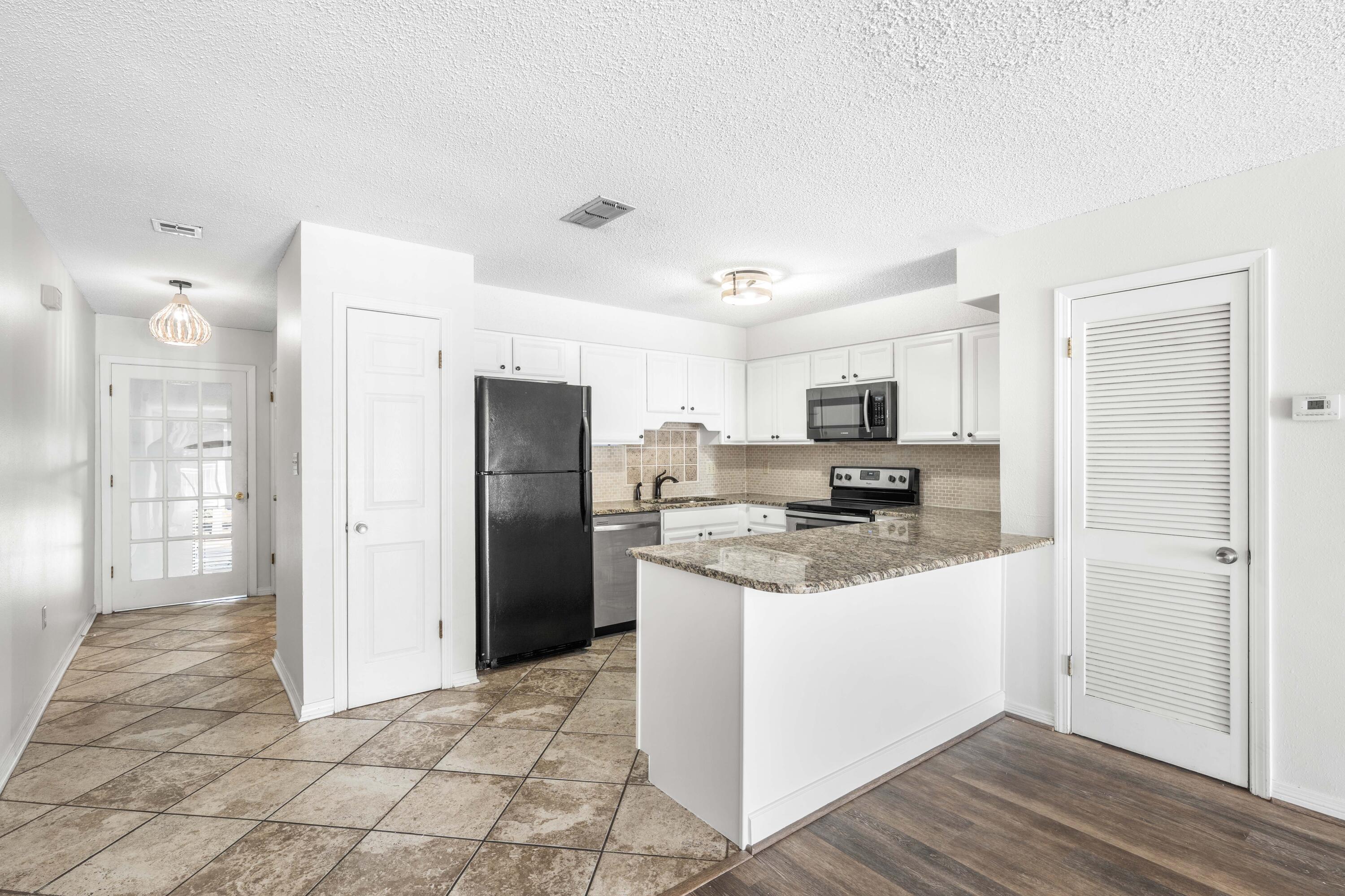 3654 East County Highway 30A, Unit 8B Santa Rosa Beach, FL 32459 - Photo 7 of 42 a kitchen with stainless steel appliances granite countertop a refrigerator and a stove