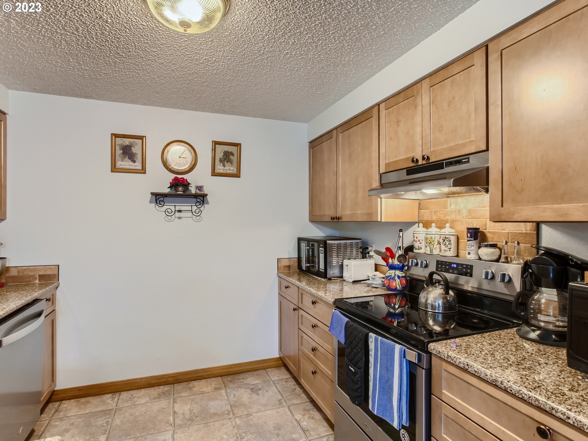 39060 Southeast Bumpy Lane Sandy, OR 97055 - Photo 3 of 29 a kitchen with stainless steel appliances granite countertop a stove a sink and a microwave