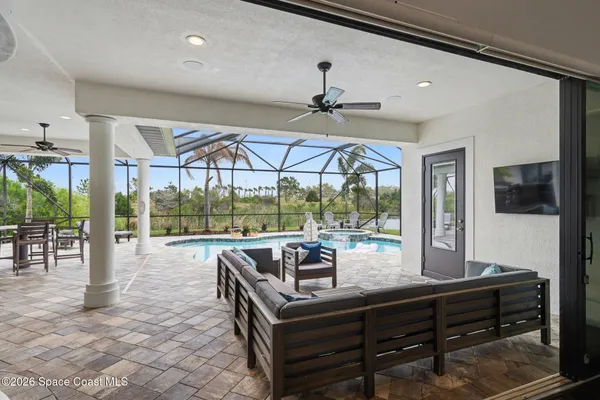 a living room with furniture a flat screen tv and a floor to ceiling window