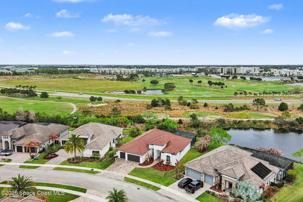 an aerial view of residential houses with outdoor space and lake view