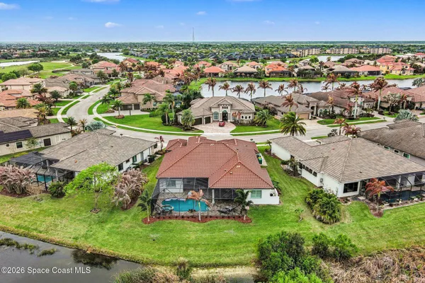 an aerial view of residential houses with outdoor space and trees