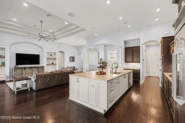 a large white kitchen with a large window and stainless steel appliances
