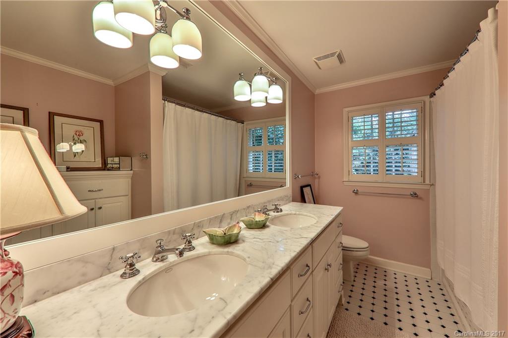 3214 Colony Road Charlotte, NC 28211 - Photo 18 of 24 a bathroom with a sink a large mirror and a light fixture