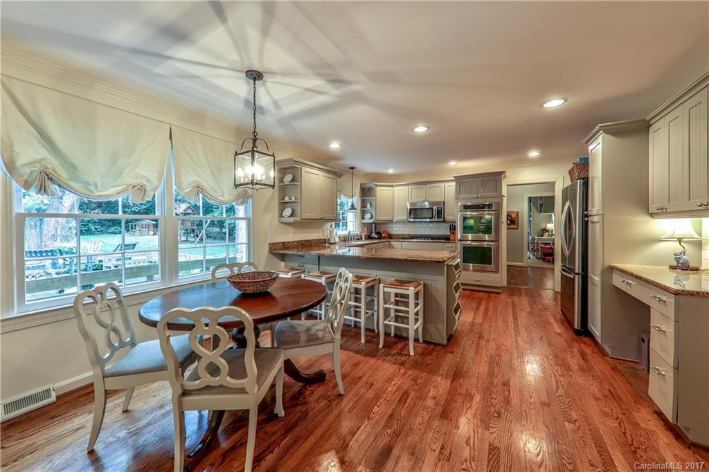 3214 Colony Road Charlotte, NC 28211 - Photo 8 of 24 a kitchen with stainless steel appliances kitchen island granite countertop a table chairs and a wooden floor