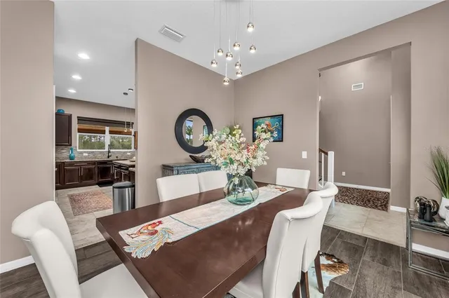 a kitchen with stainless steel appliances kitchen island granite countertop a table and chairs in it