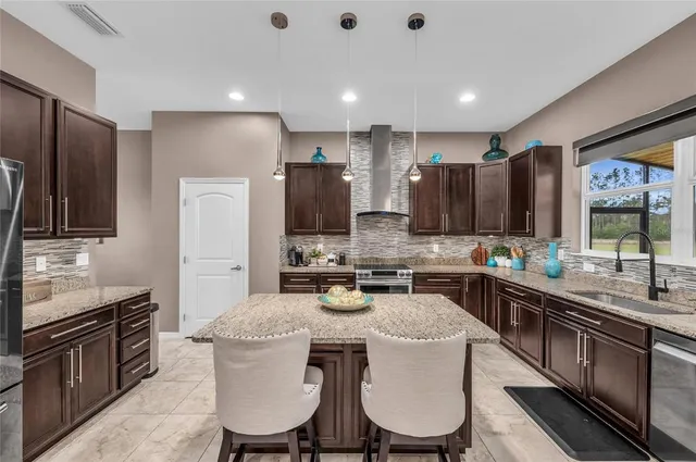 a kitchen with stainless steel appliances granite countertop a sink stove and cabinets