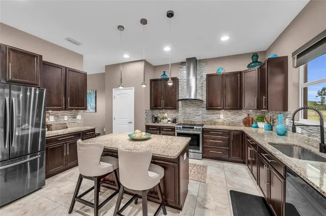 a kitchen with kitchen island granite countertop a sink stove and refrigerator