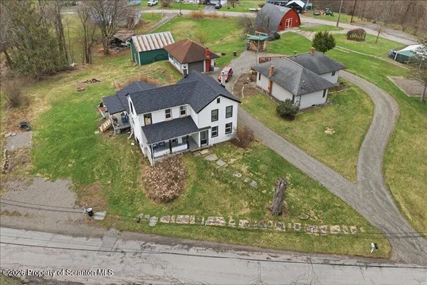 an aerial view of a house with garden space ocean and mountain view in back