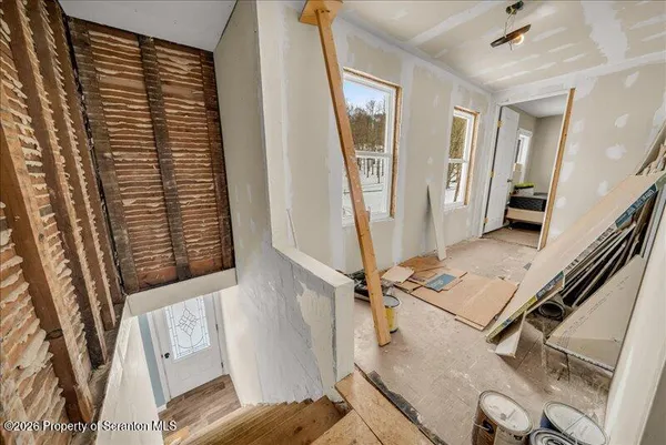 a view of a livingroom with wooden floor and stairs