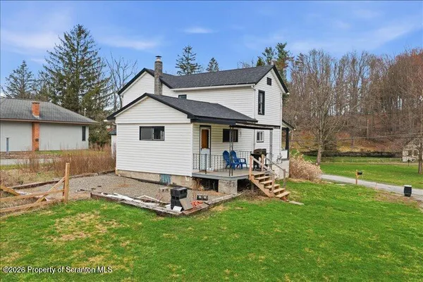 a view of a house with backyard and a tree