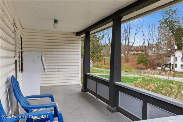 a view of a porch with furniture and wooden floor