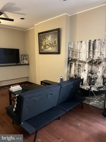 a living room with furniture a flat screen tv and gym equipment