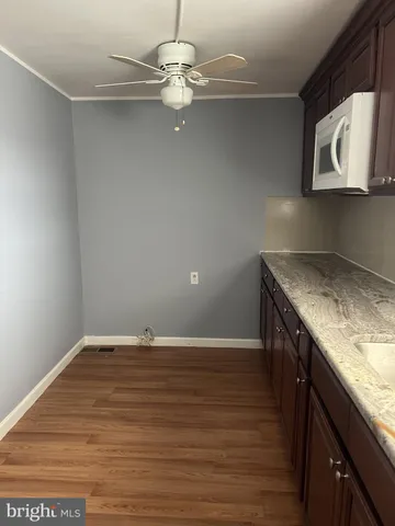 a view of a kitchen sink and dishwasher with wooden floor