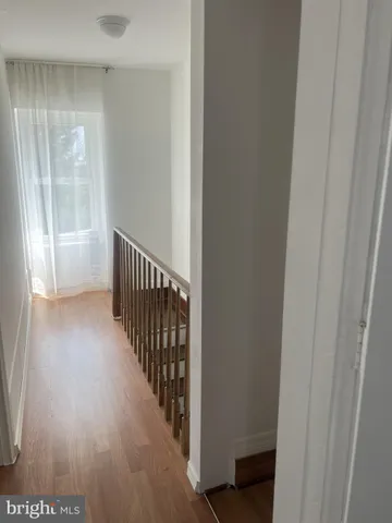 a view of a hallway with wooden floor and a view of a hallway