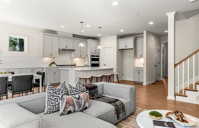 a living room with furniture and a dining table with kitchen view