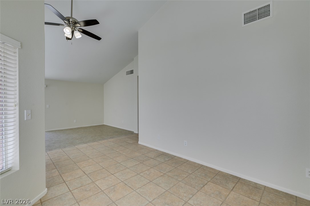 307 Cavalla Street Henderson, NV 89074 - Photo 21 of 44 The generously proportioned living space features vaulted ceilings and resilient tile flooring, seamlessly connecting to a carpeted area.
