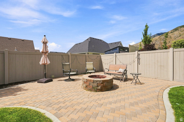1997 East 600 South Springville, UT 84663 - Photo 7 of 54 Paver patio featuring a built-in stone-clad fire pit, surrounded by a privacy fence