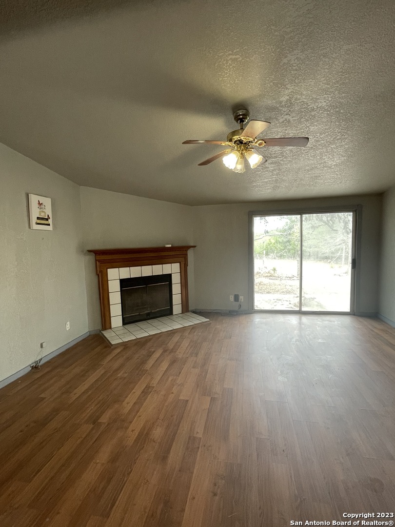 125 Pecan Drive Spring Branch, TX 78070 - Photo 6 of 12 an empty room with windows and a fireplace