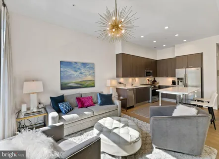 a living room with furniture and kitchen view