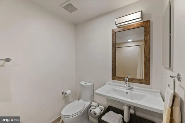 a bathroom with a toilet a sink and mirror