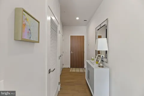 a view of a hallway with bathroom and mirror