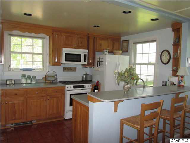 664 Horseshoe Bend Road Deltaville, VA 23043 - Photo 4 of 12 a kitchen with granite countertop a stove a sink a dining table and chairs
